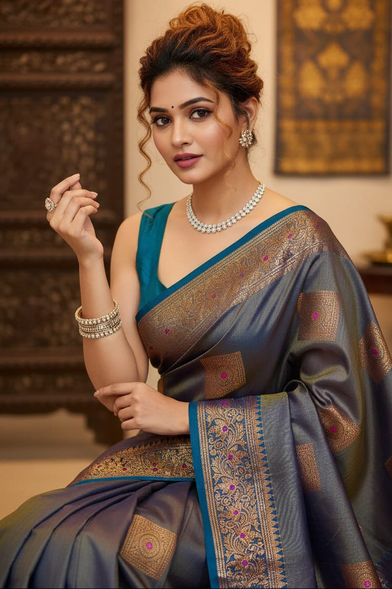 Woman in a traditional saree with intricate patterns, posing indoors.
