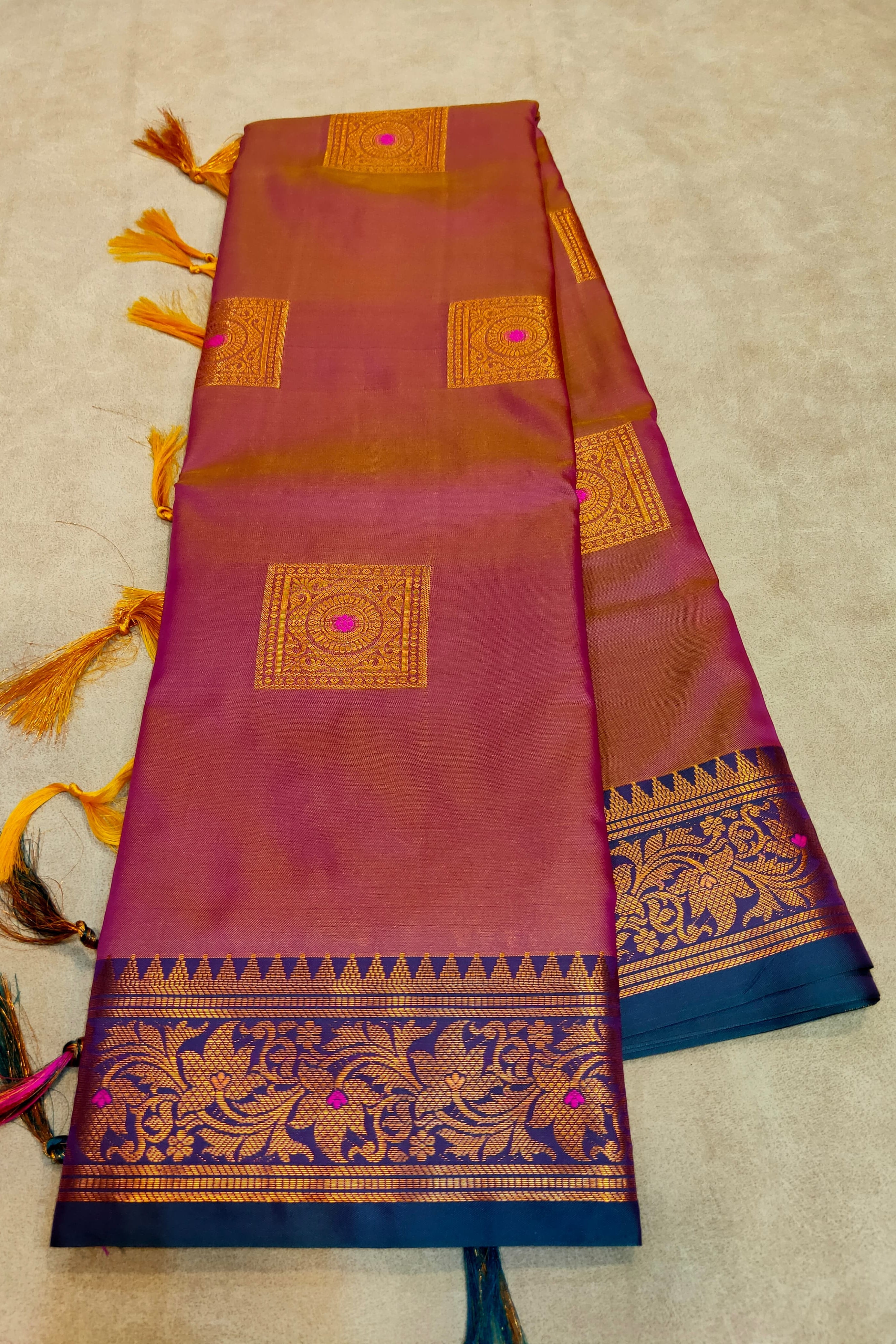 Woman wearing a green saree with intricate patterns indoors.
