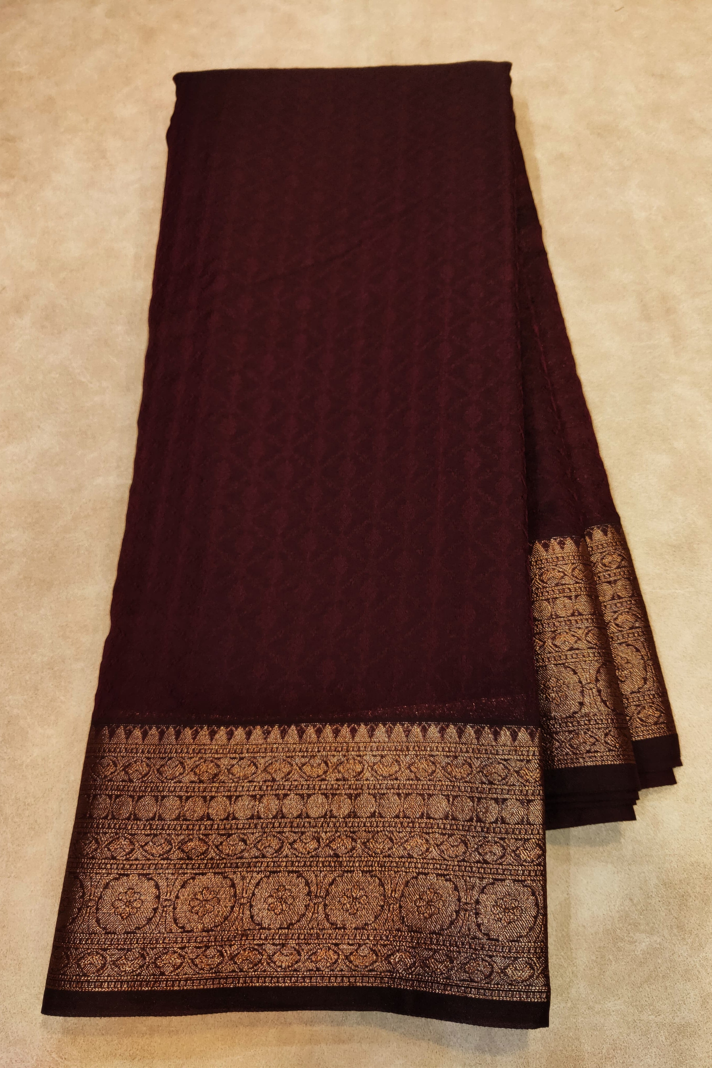 Brown fabric with intricate patterns on a beige background