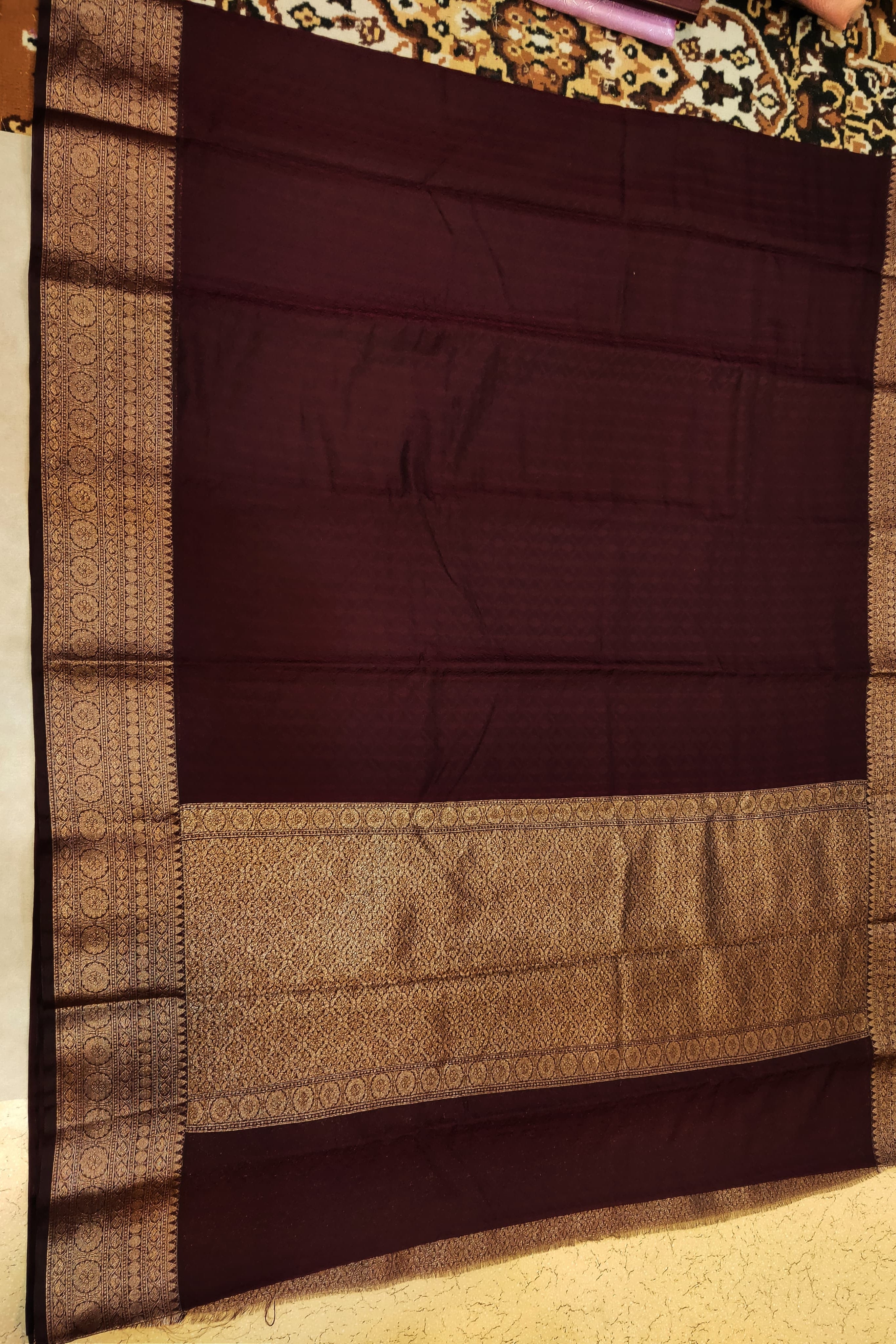 Brown fabric with a patterned border on a plain background