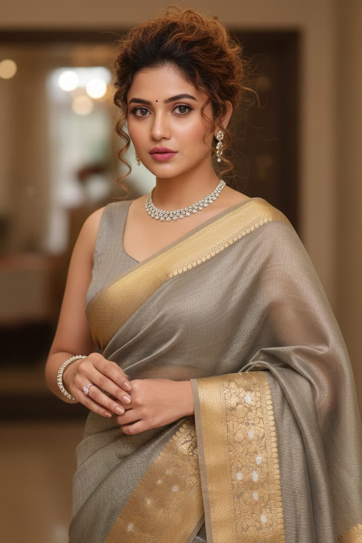 Woman in a traditional saree with a blurred indoor background
