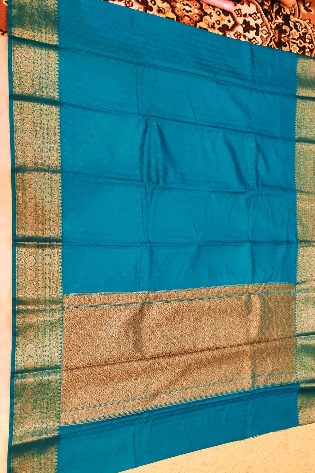Blue and green traditional fabric with a patterned background