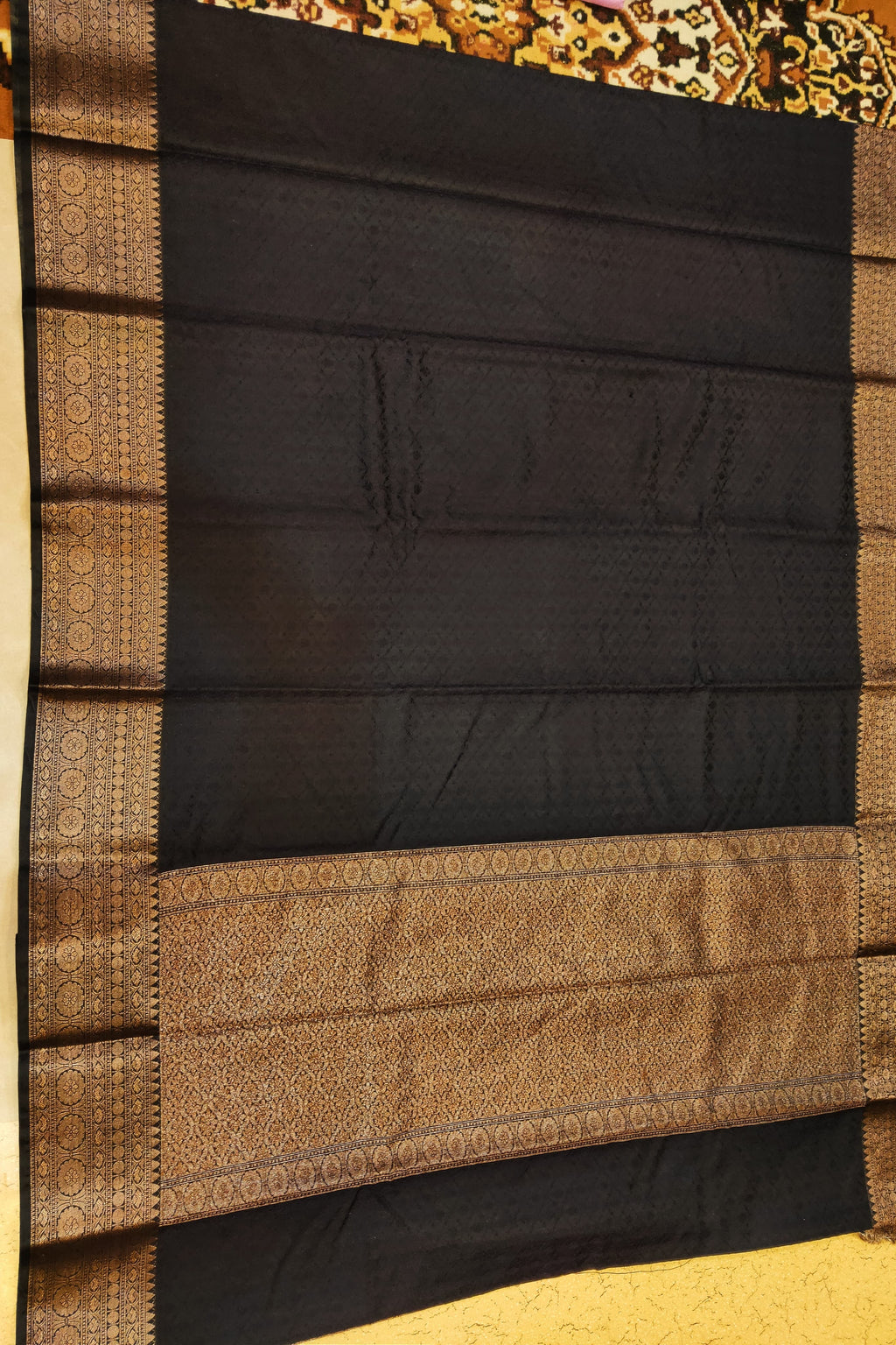 Black and brown saree with intricate patterns on a plain background