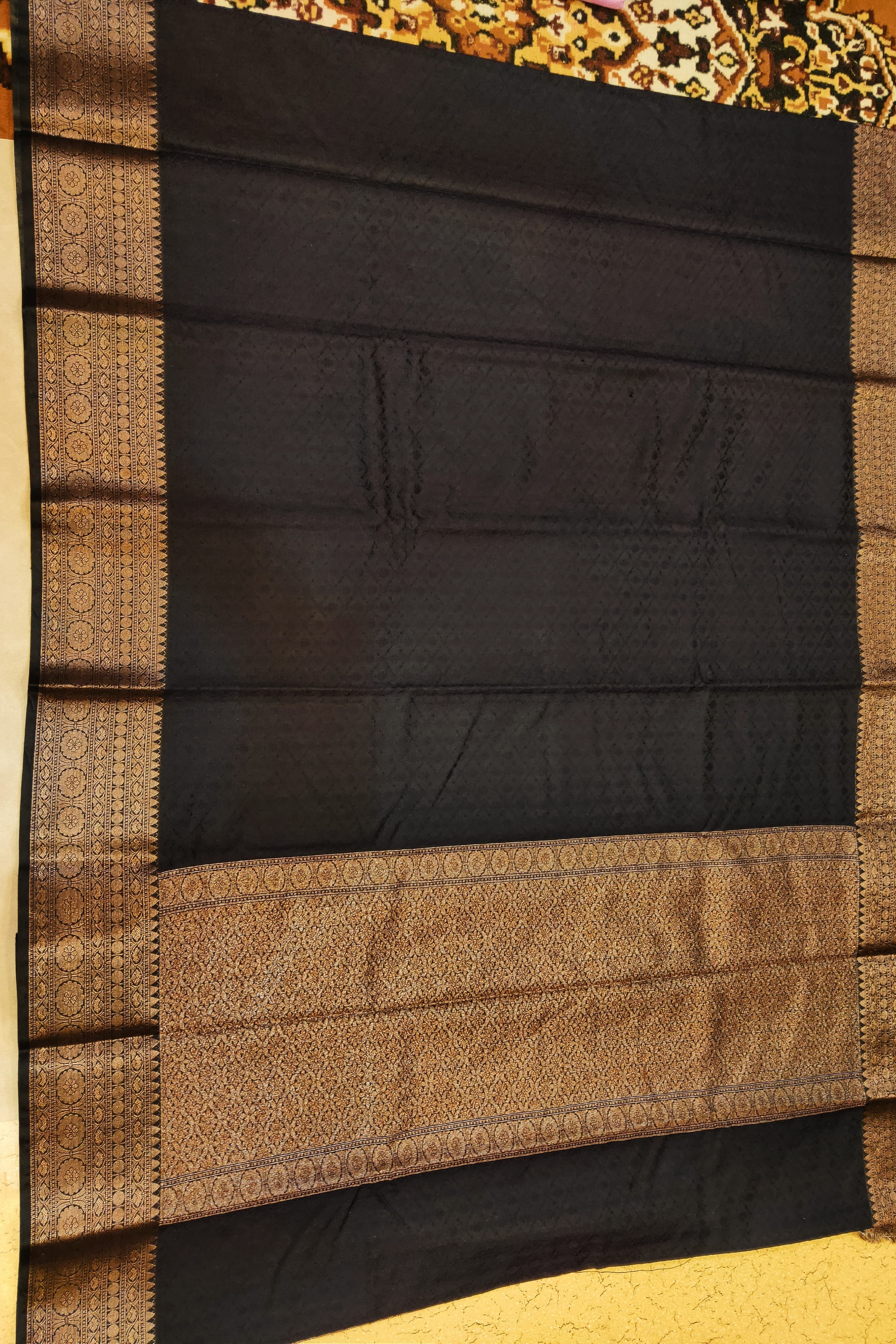 Black and brown saree with intricate patterns on a plain background