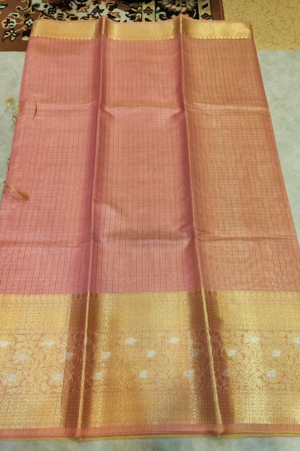 Saree with pink and gold border on a neutral background