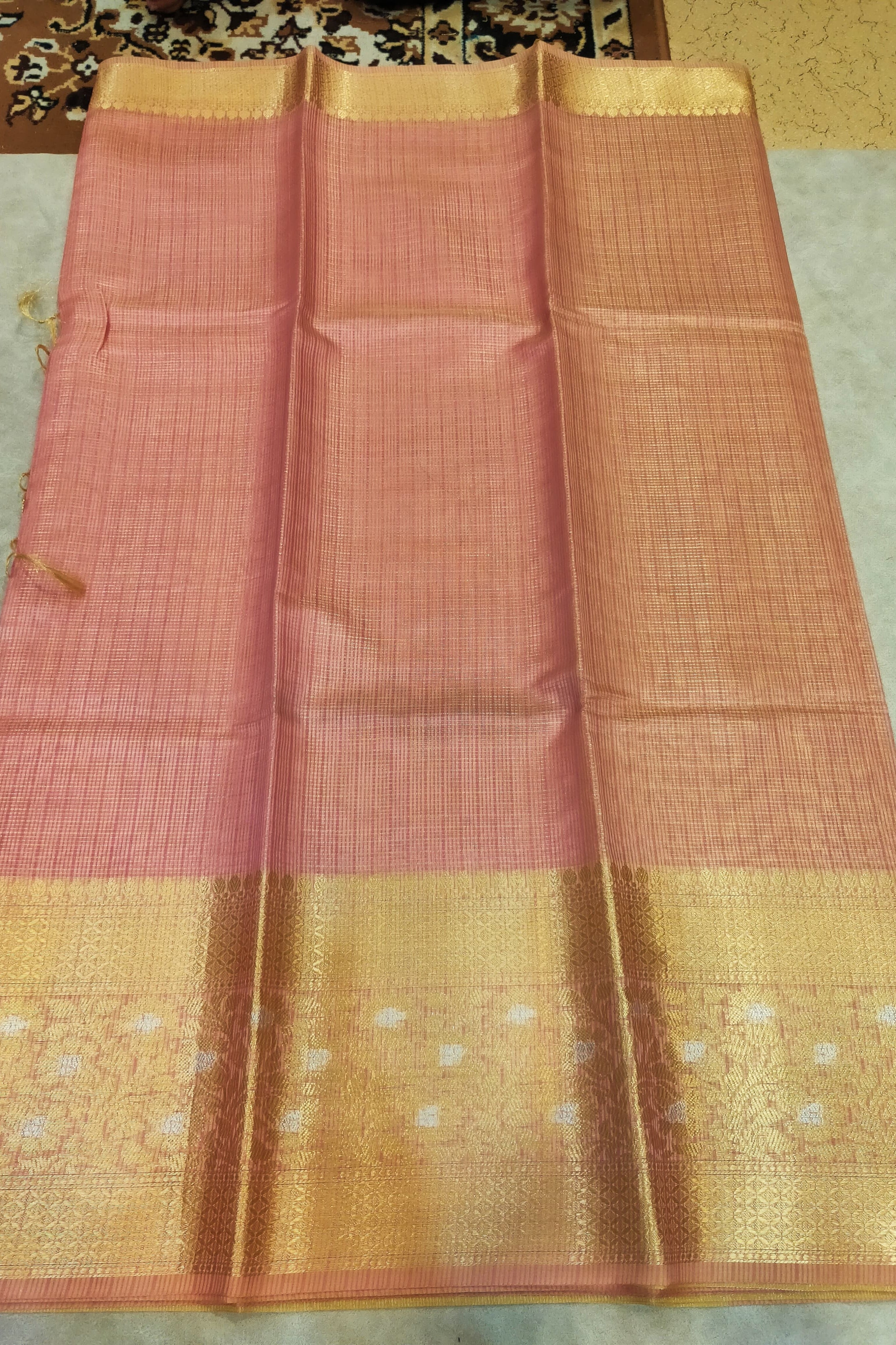 Saree with pink and gold border on a neutral background