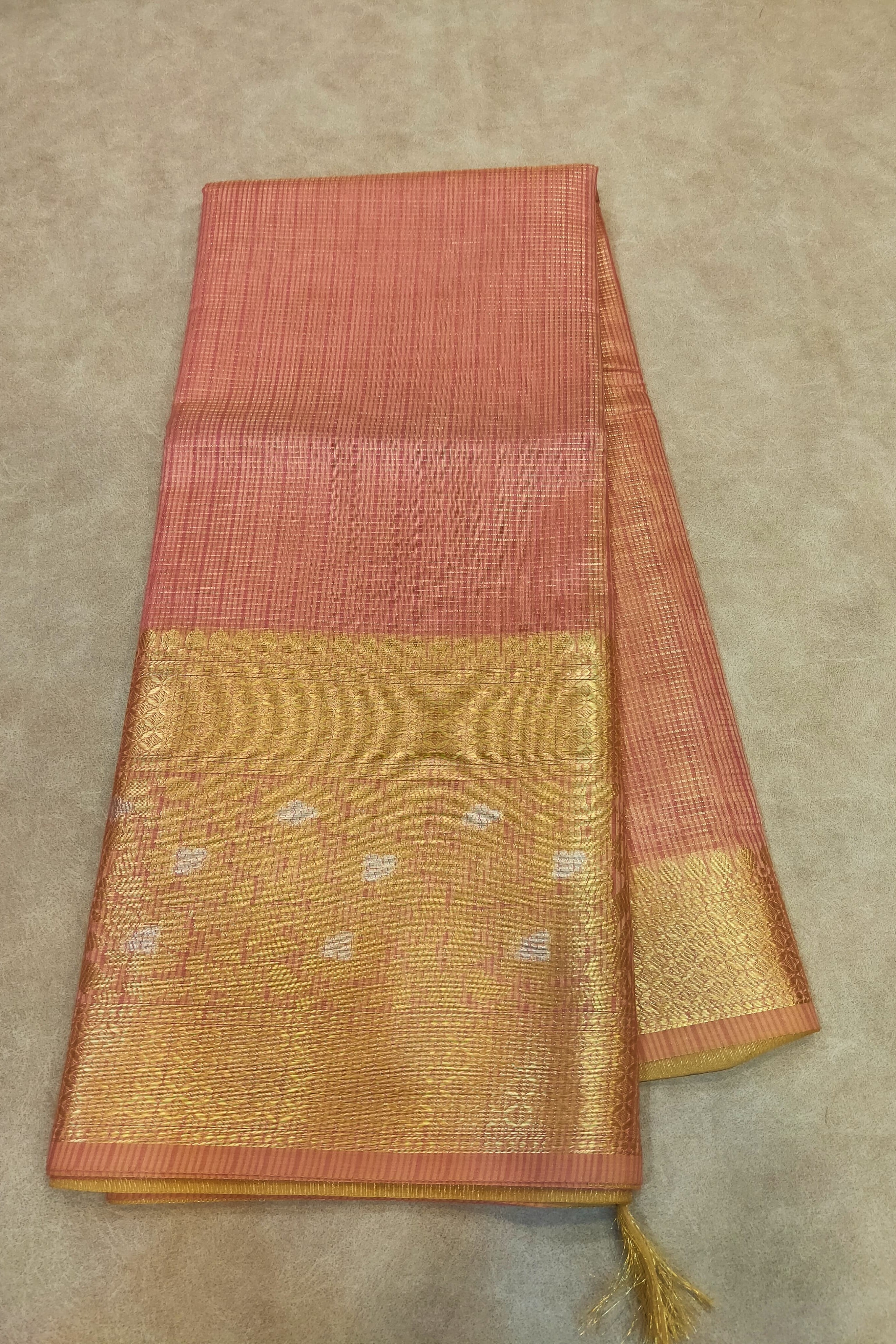 Saree with a red and gold pattern on a beige background