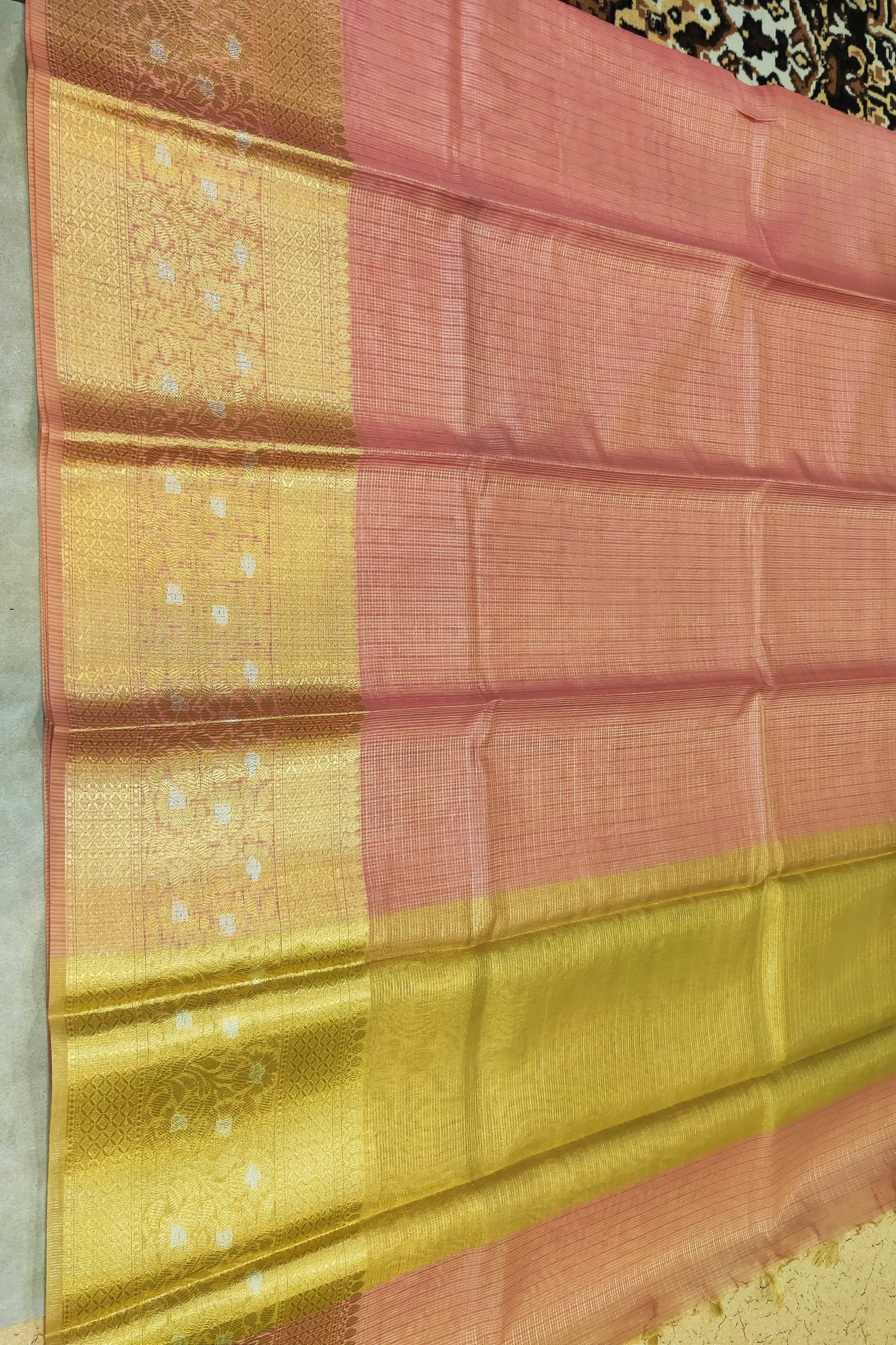 Saree with pink and gold pattern on a plain background