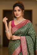 Woman wearing a green and pink saree with jewelry indoors