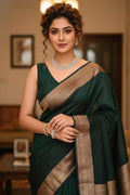 Woman in a green saree with gold border indoors
