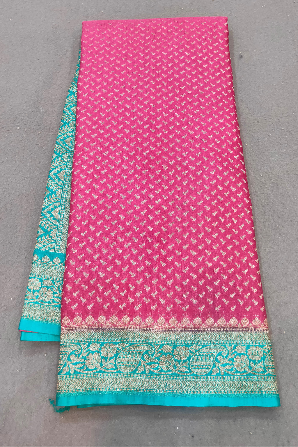 Pink fabric with green border on a gray background