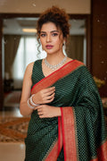 Woman wearing a green saree with red border indoors