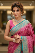 Woman in a pink saree with a blurred indoor background