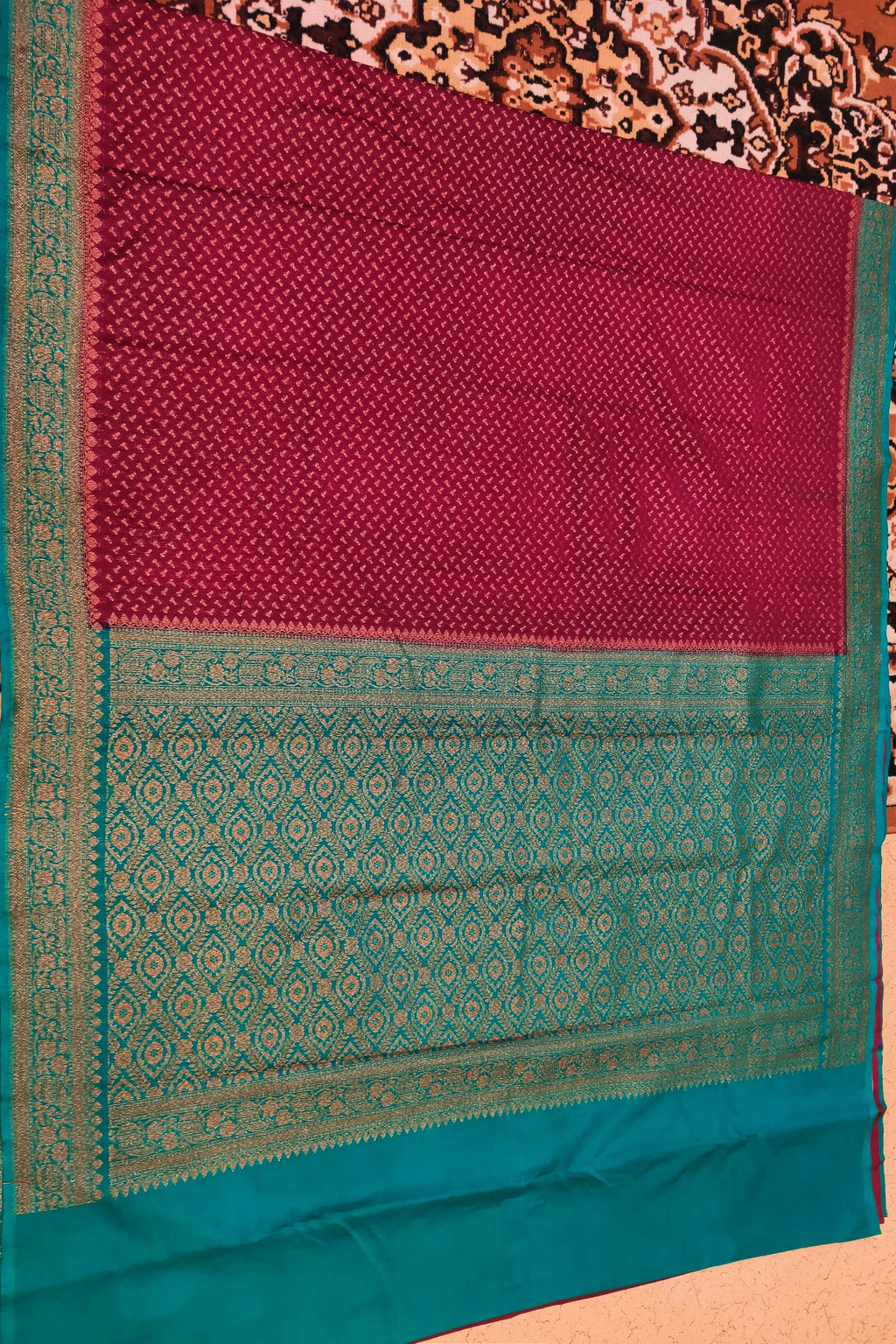 Maroon and teal saree with a patterned background