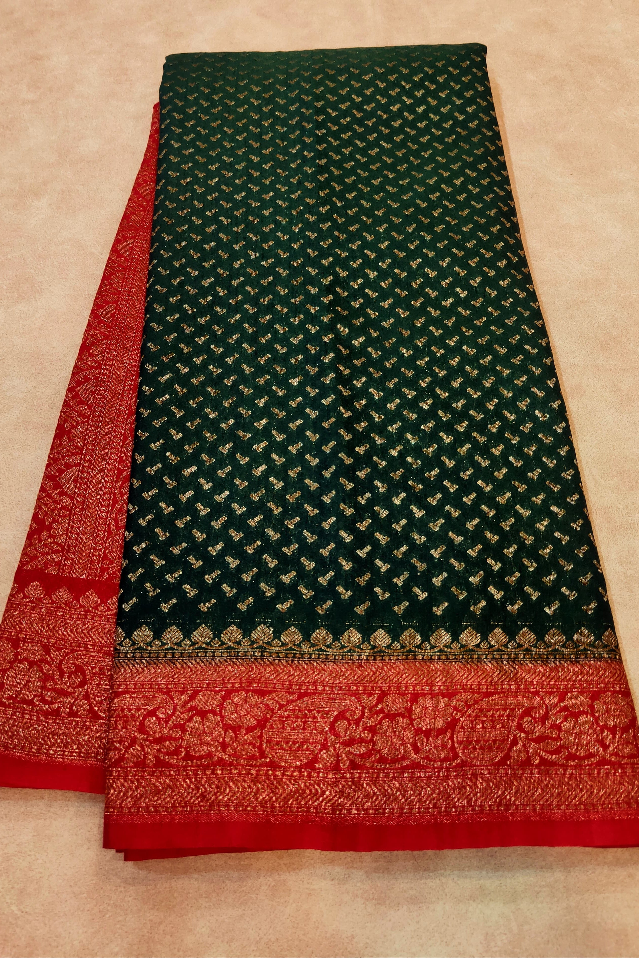 Green and red fabric with intricate patterns on a beige background