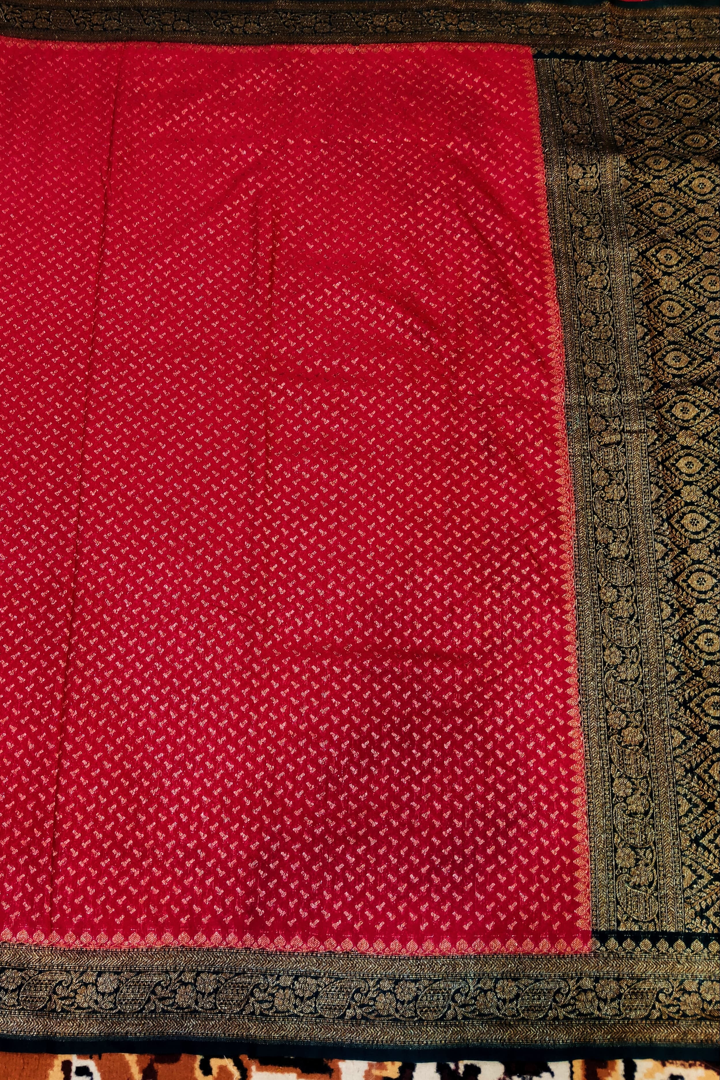 Red fabric with black border on a patterned background