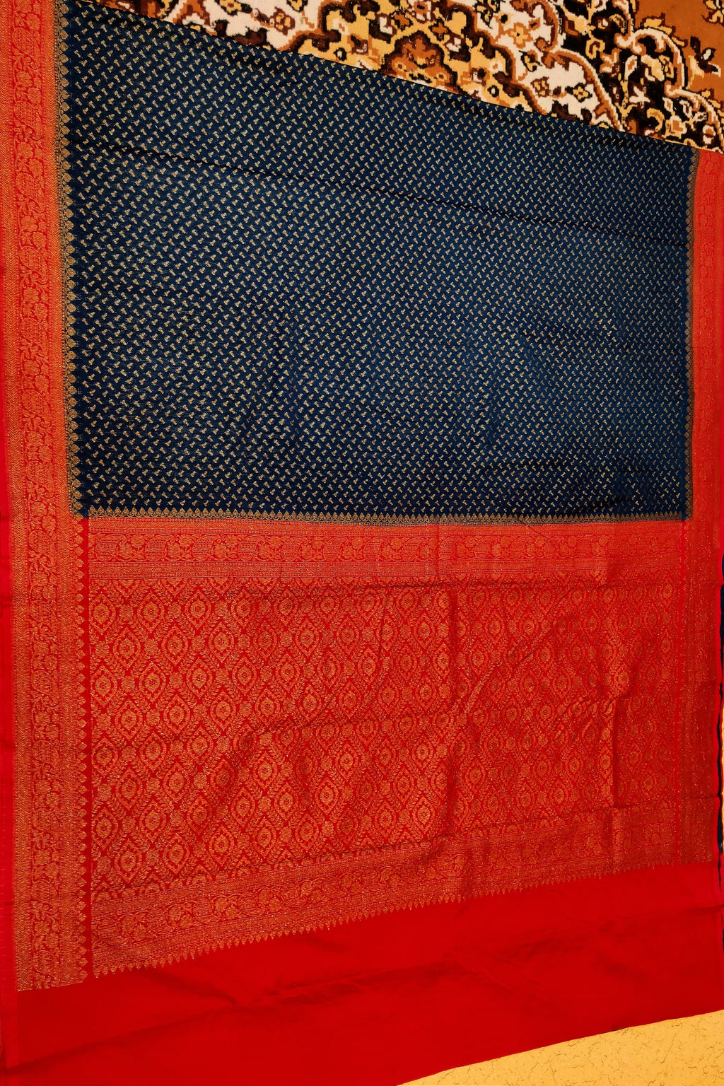 Red and black patterned fabric with intricate designs on a plain background