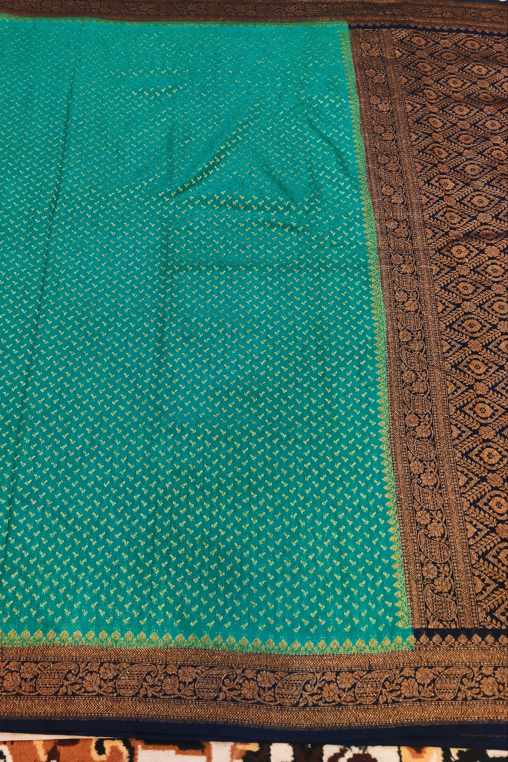 Green fabric with brown border on a patterned carpet