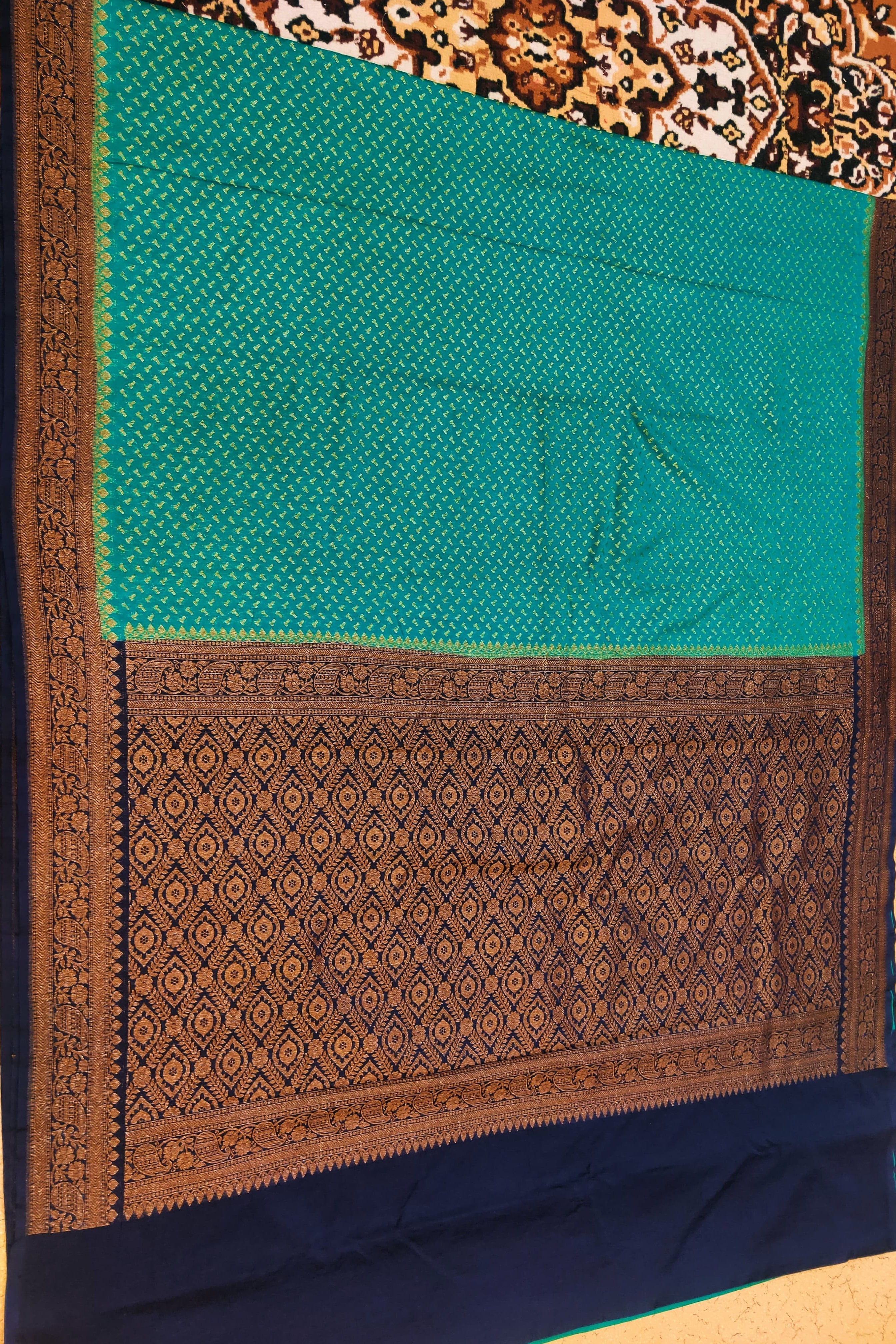 Teal fabric with brown border on a patterned background
