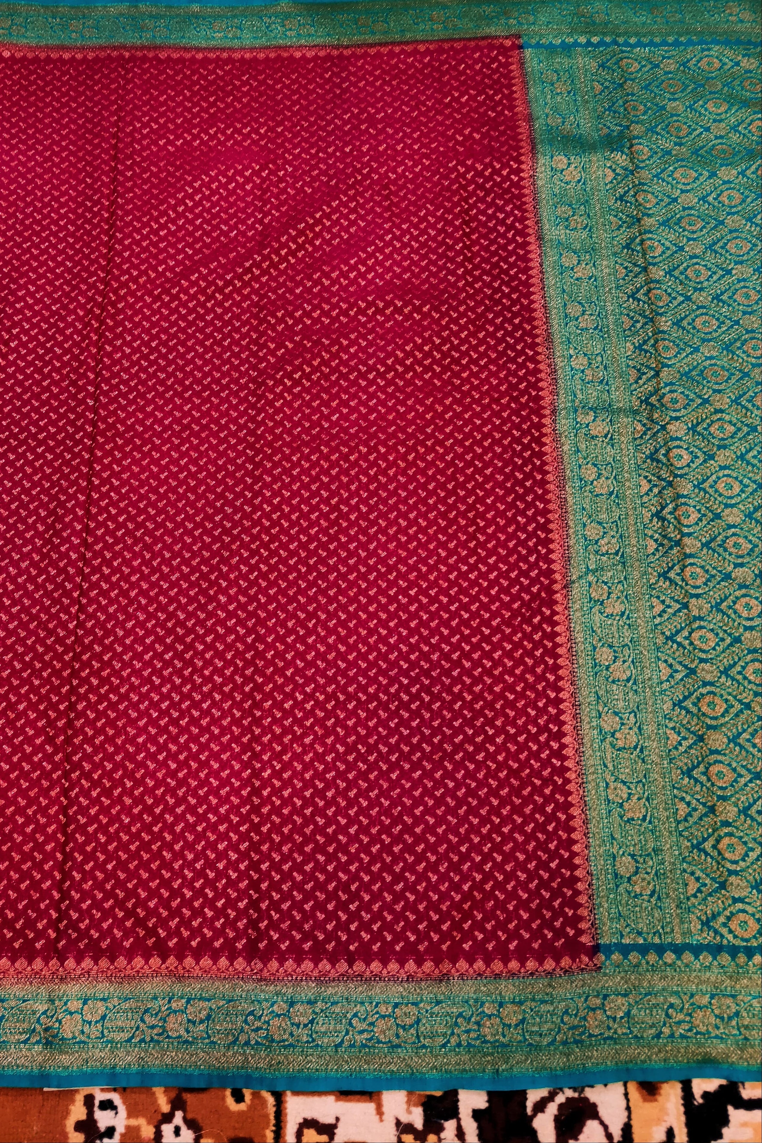 Red fabric with green border on a patterned background