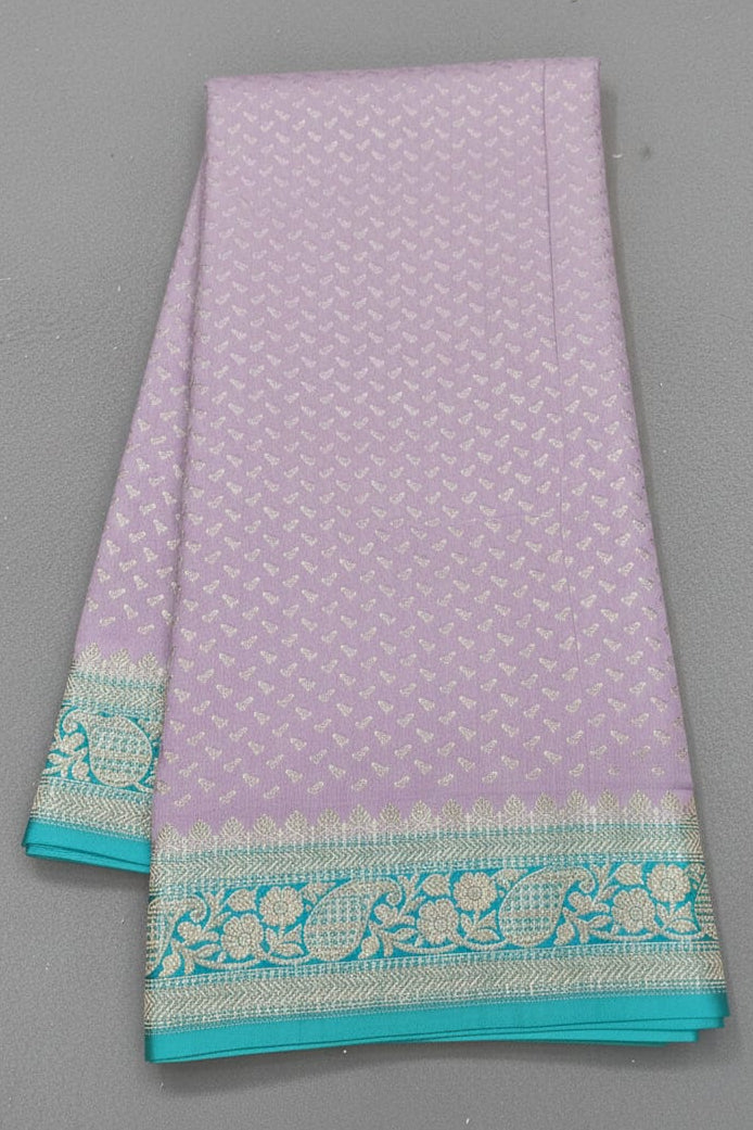 Purple saree with green border on a gray background