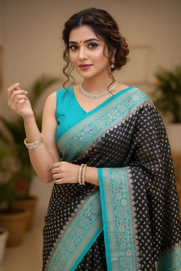 Woman wearing a black and blue saree with a blurred indoor background