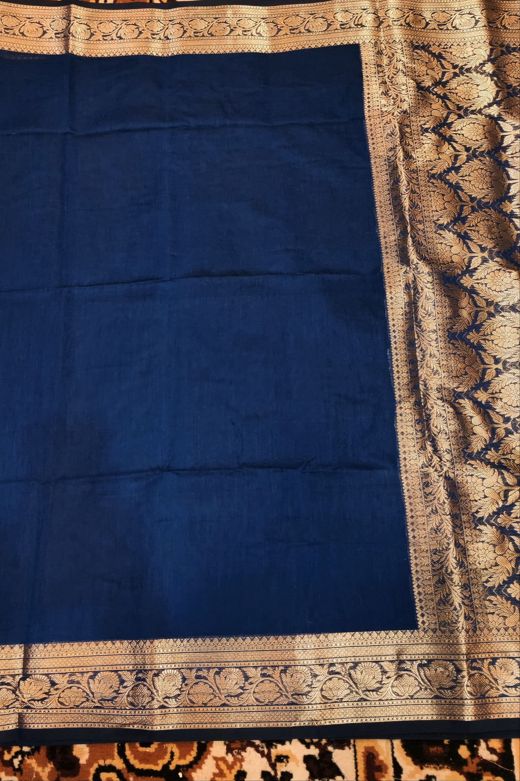 Blue fabric with intricate border on a patterned background