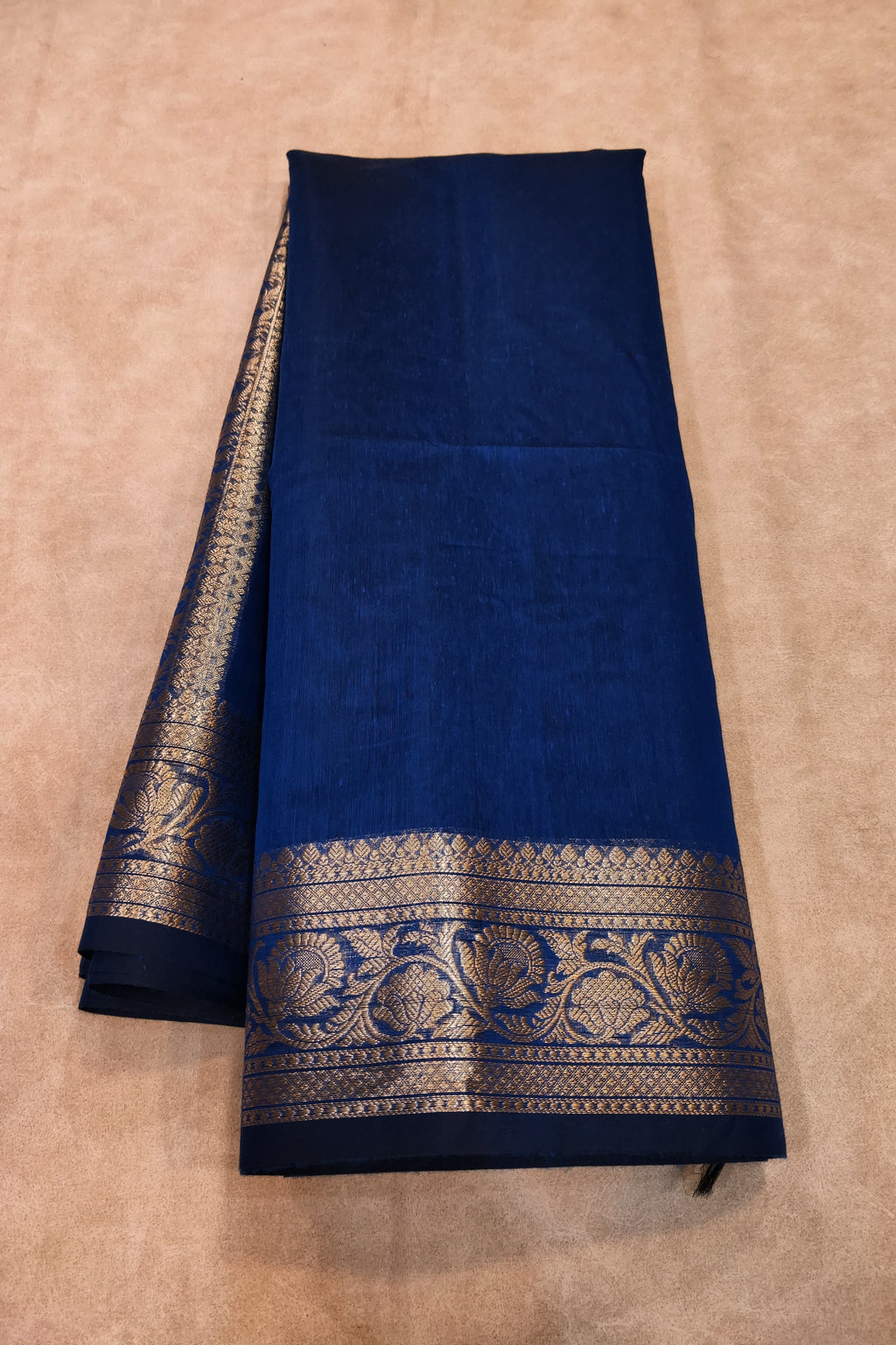 Blue fabric with gold embroidery on a beige background