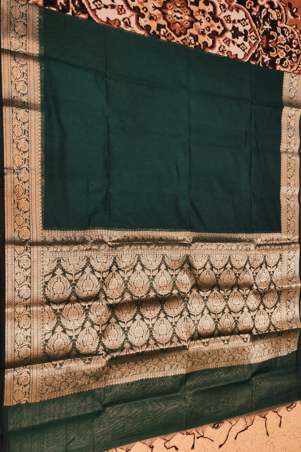 Dark green fabric with intricate gold patterns on a textured background