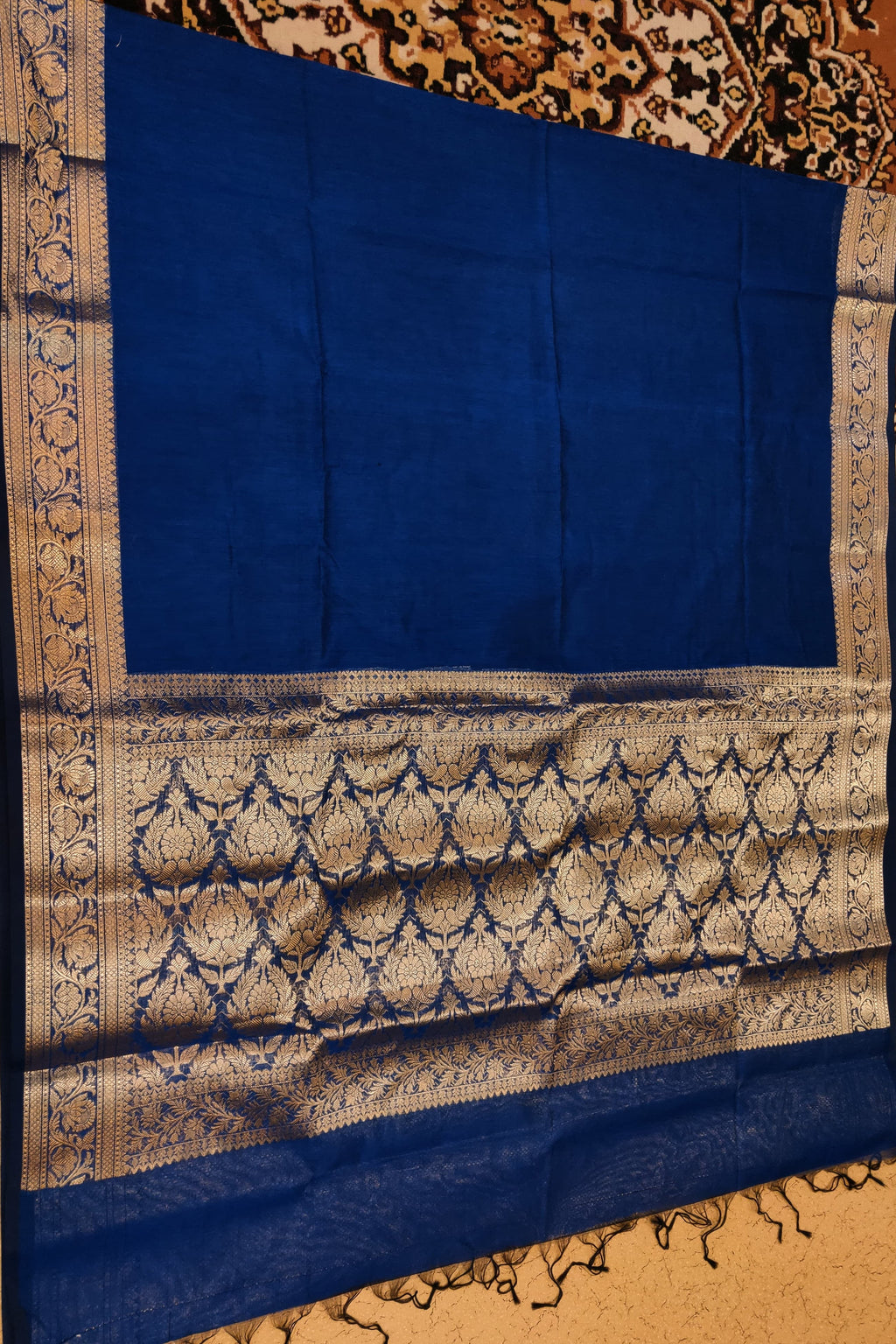 Blue fabric with intricate white patterns on a textured surface