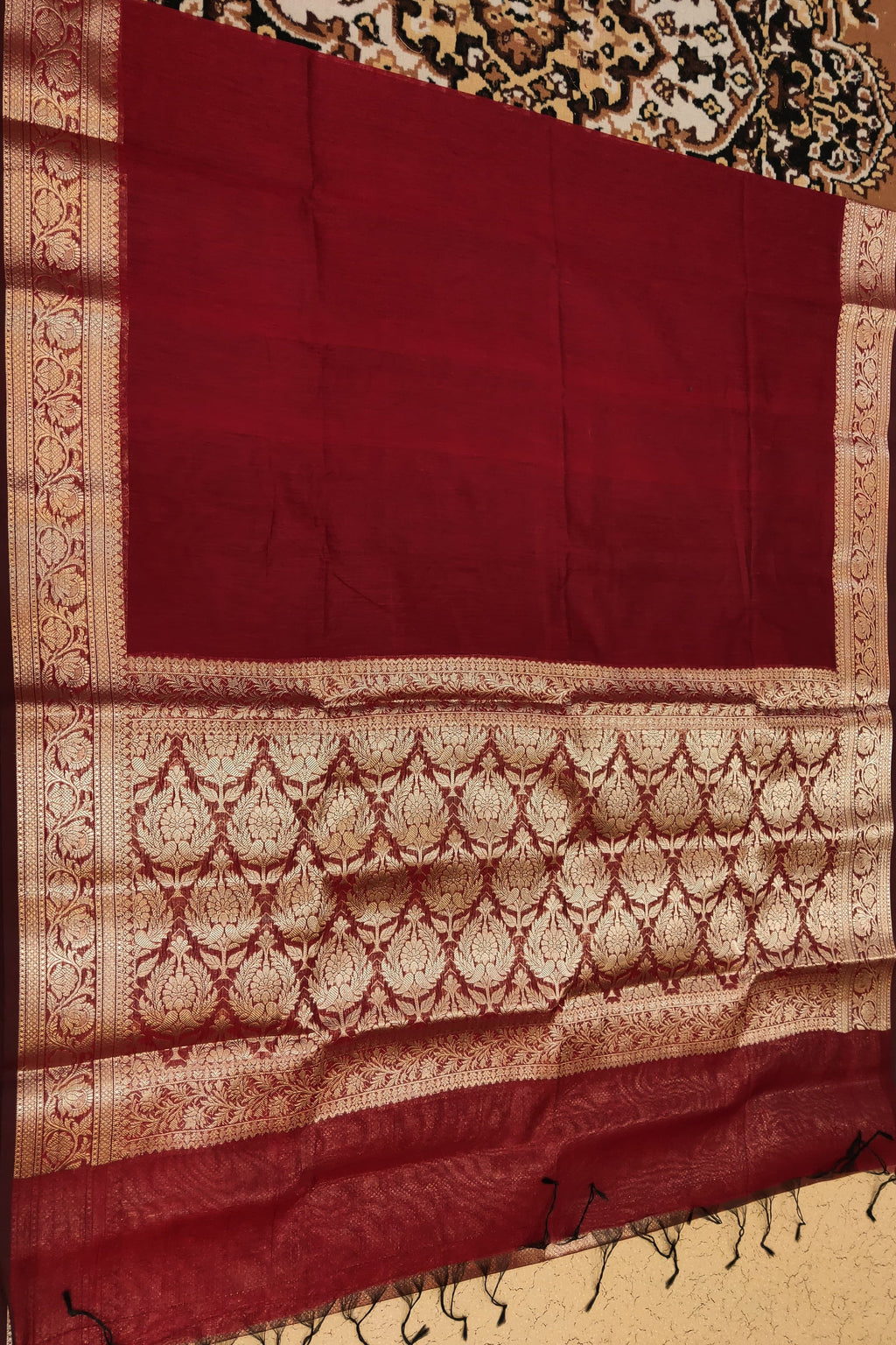 Red scarf with intricate patterns on a textured surface