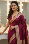 Woman in a maroon saree with gold border standing in front of a mirror.