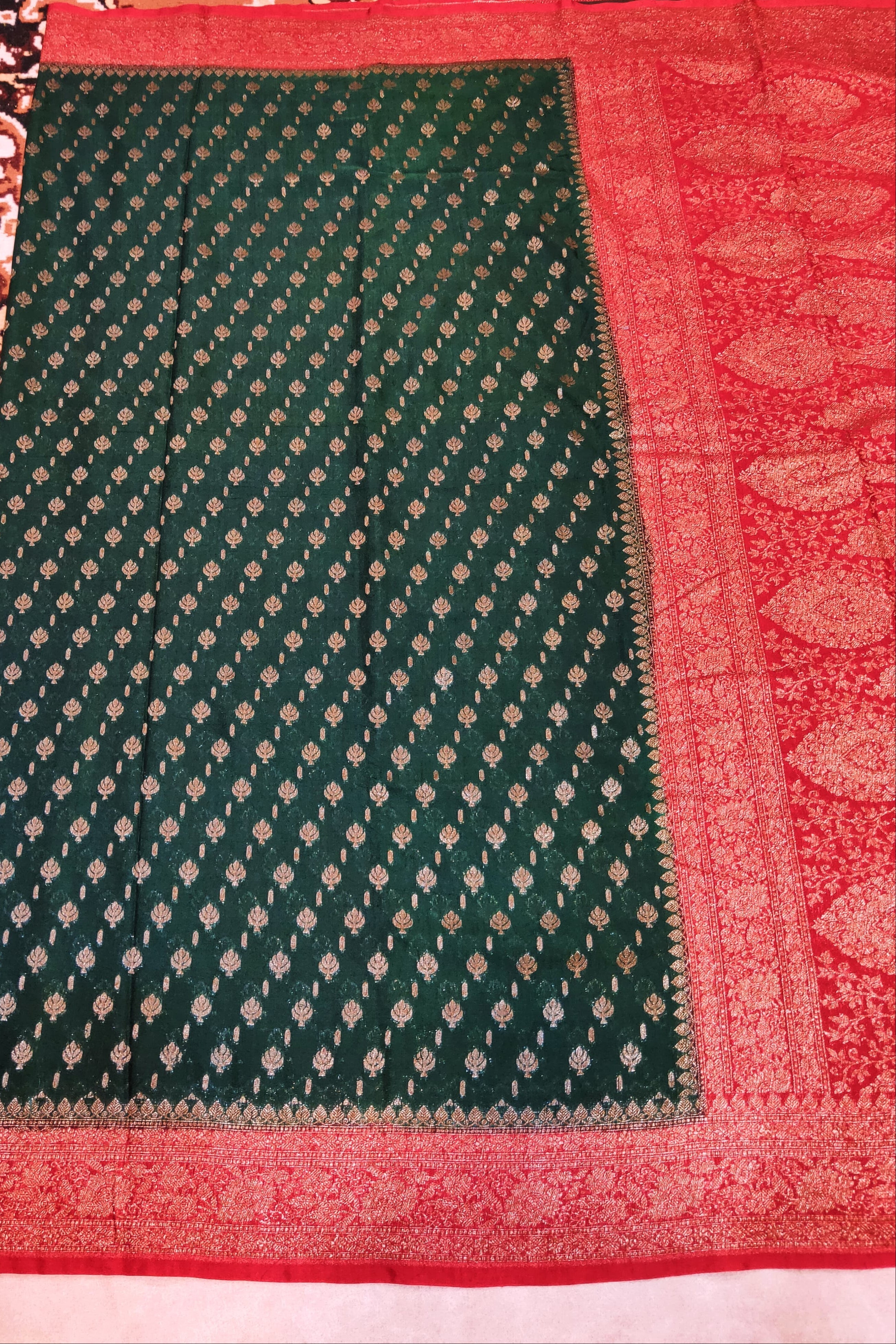 Green fabric with red border on a patterned surface