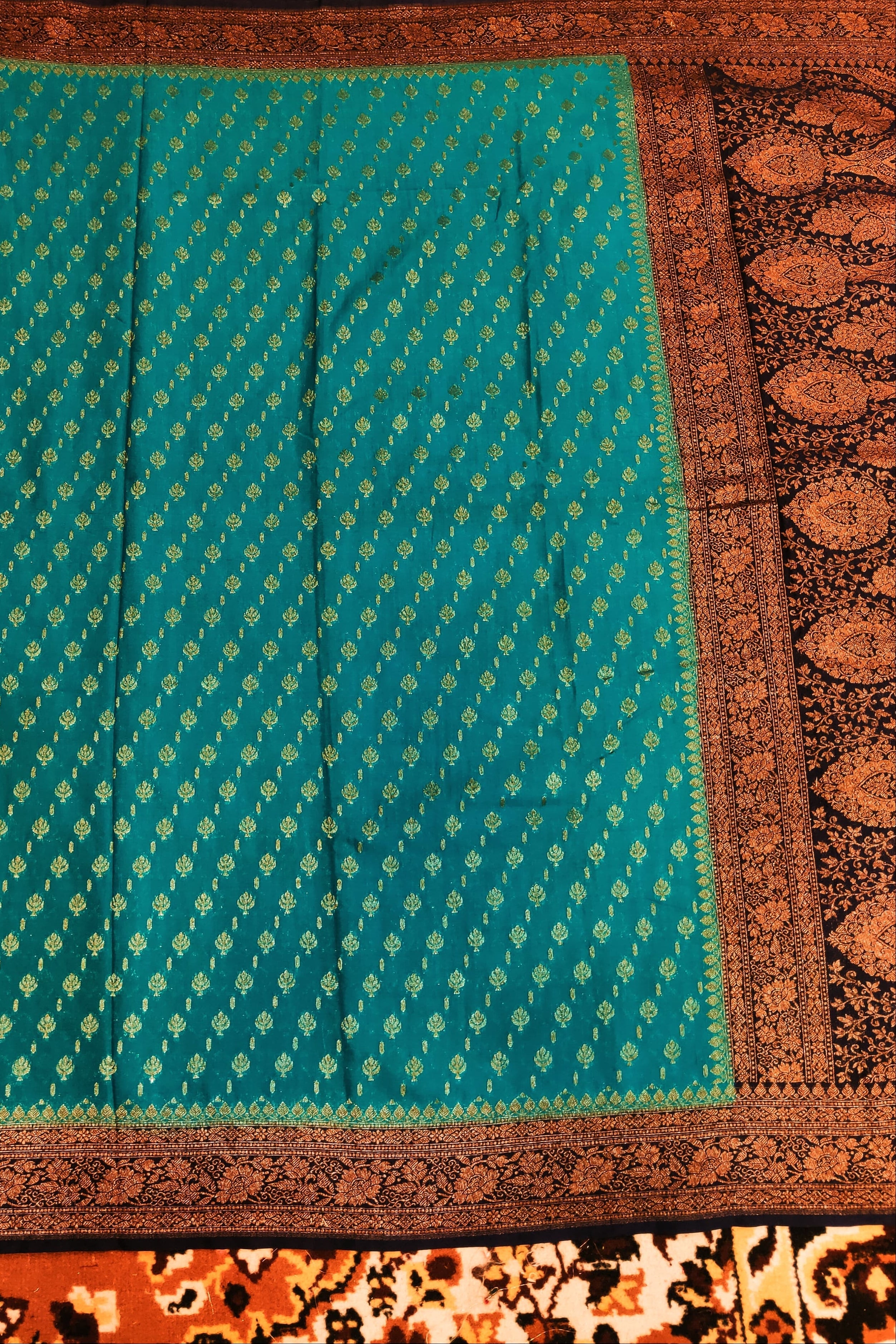 Teal fabric with brown border on a patterned background