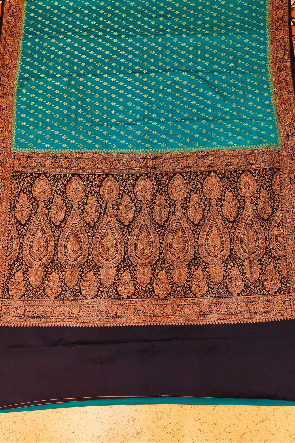 Traditional patterned fabric with a blue and brown design on a textured background