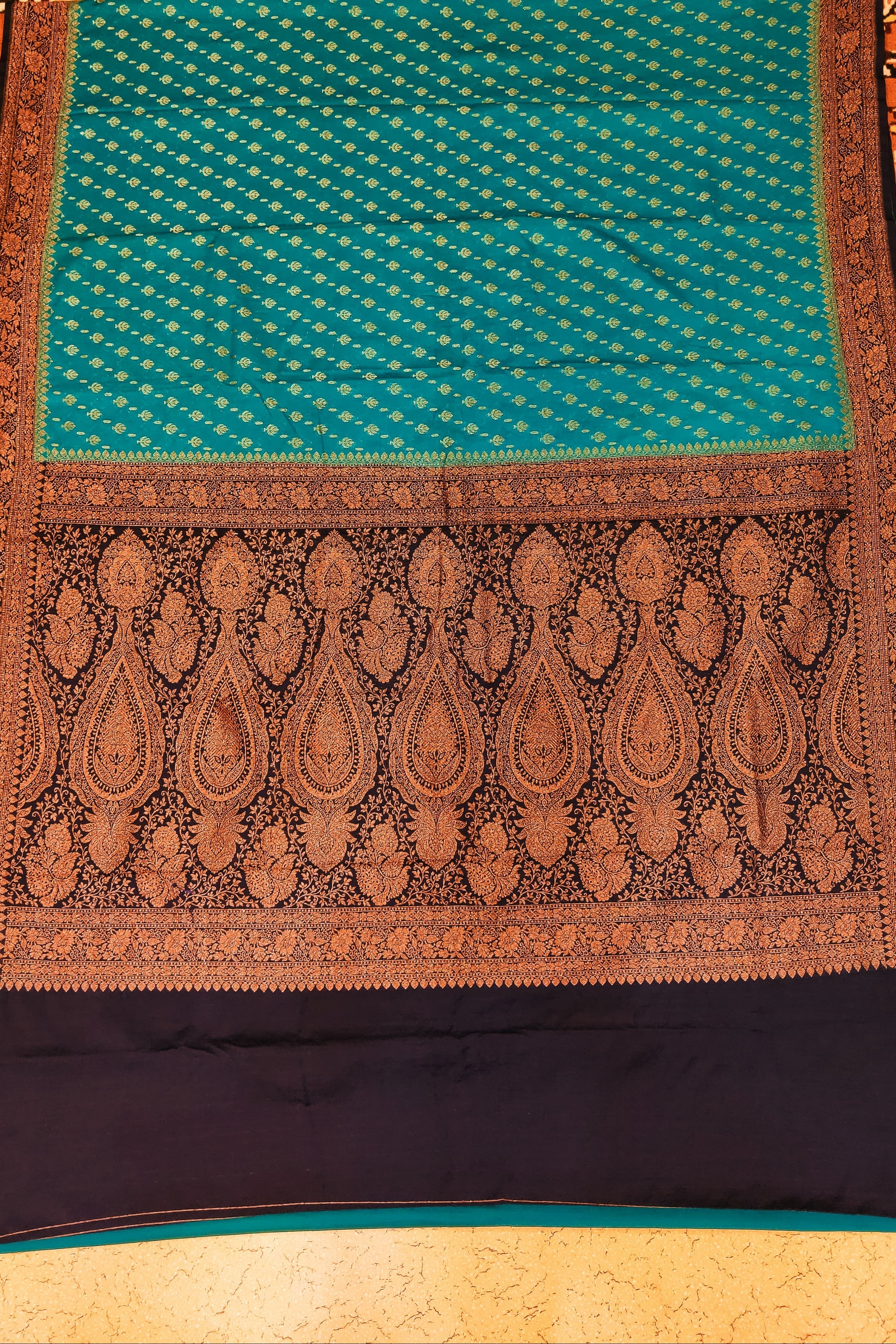 Traditional patterned fabric with a blue and brown design on a textured background