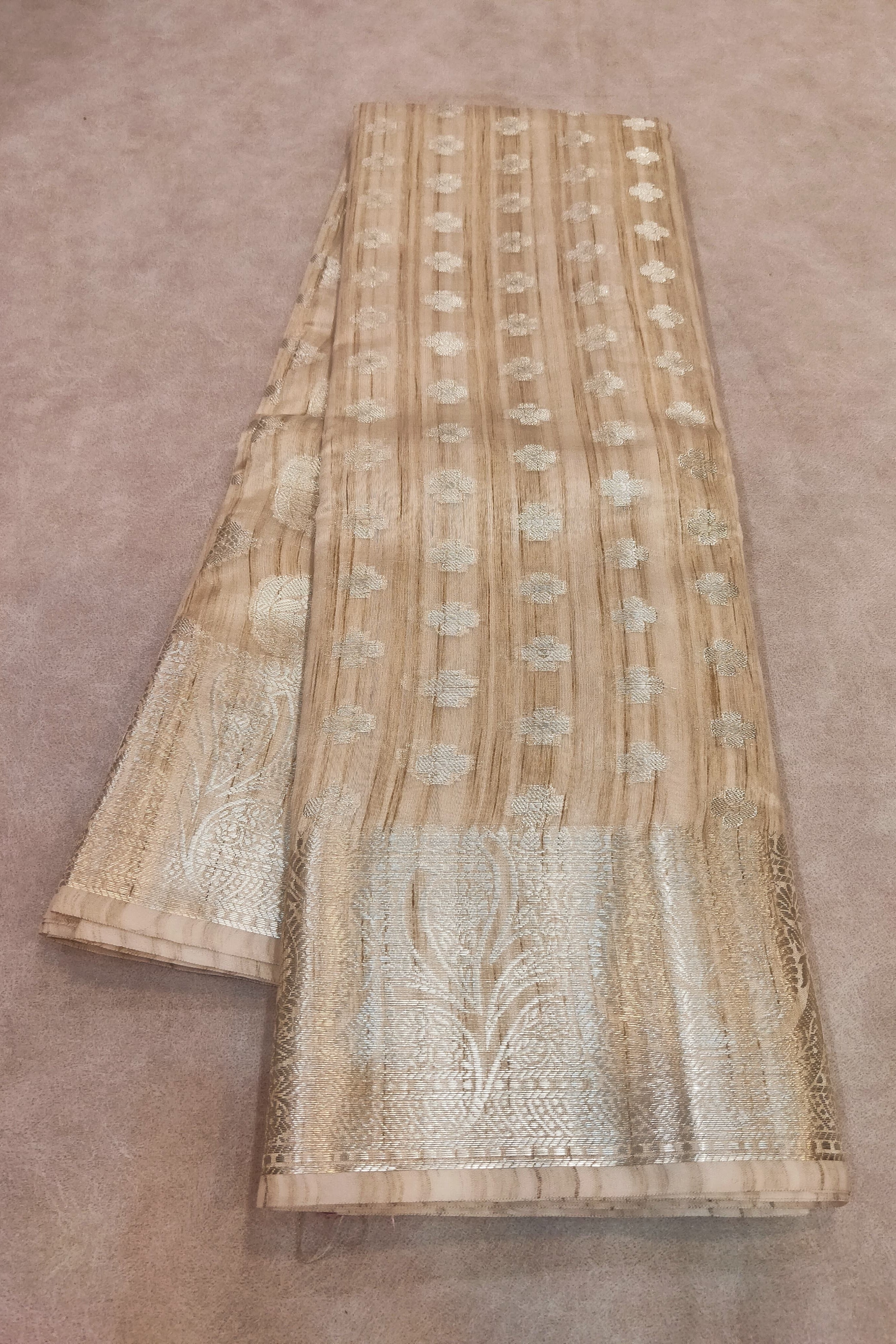 Beige fabric with intricate white patterns on a brown background