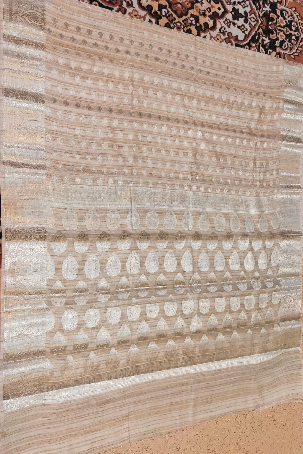 Beige patterned rug on a textured floor