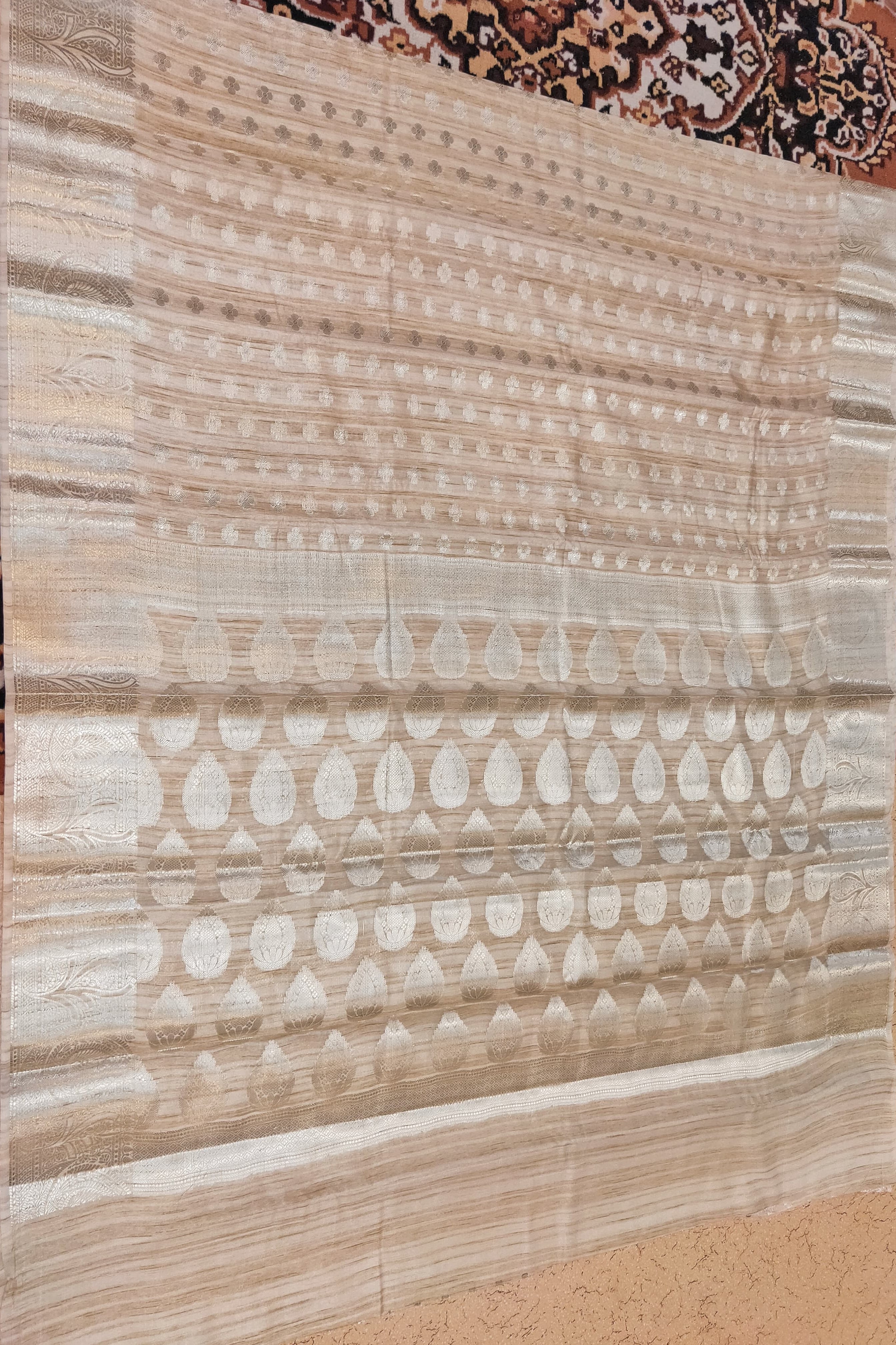 Beige patterned rug on a textured floor