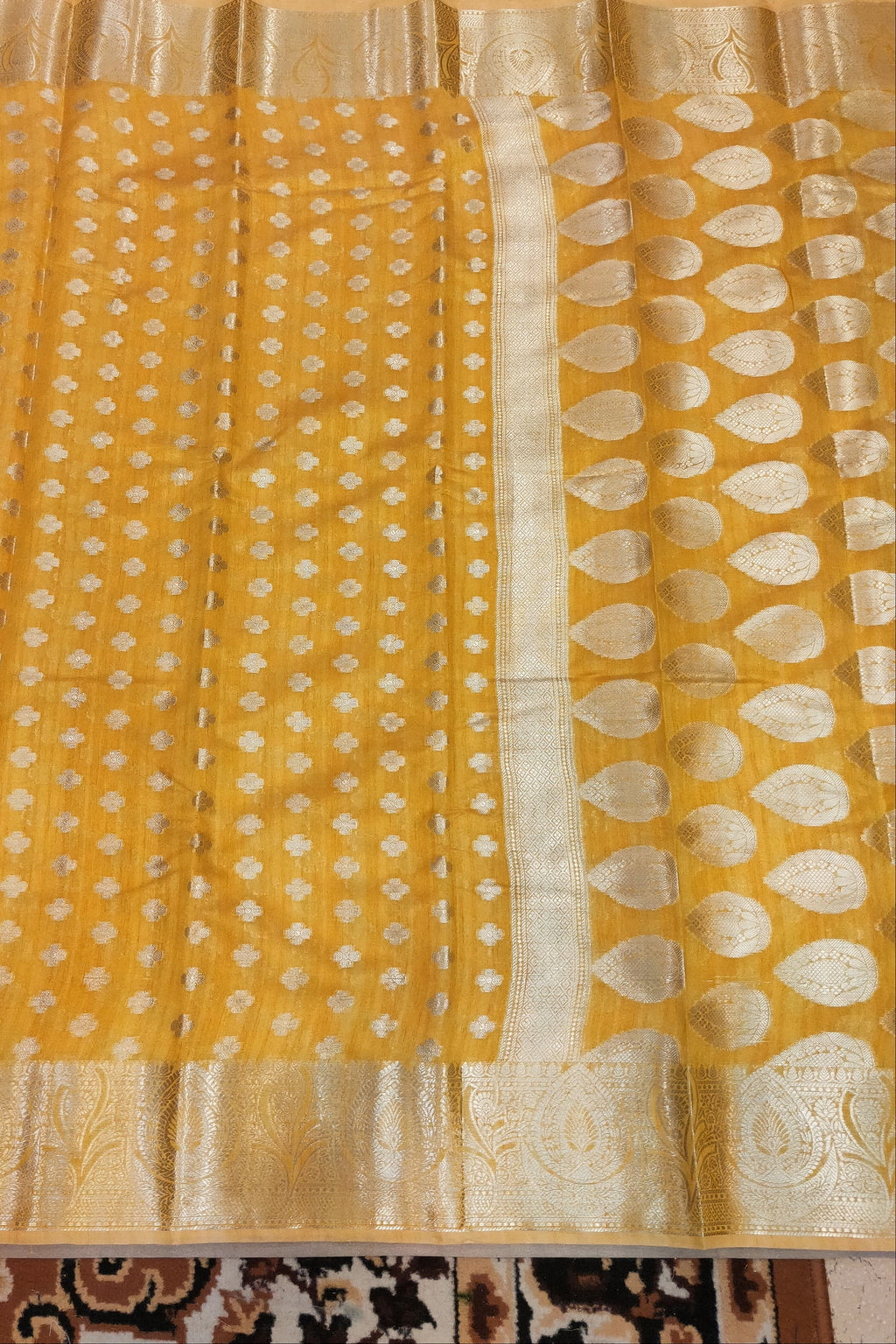 Yellow fabric with white patterns on a patterned background
