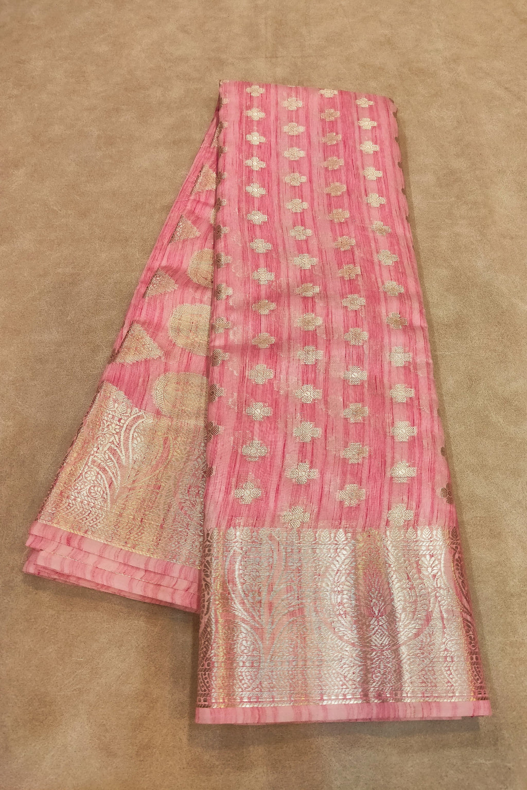 Pink saree with white patterns on a beige background