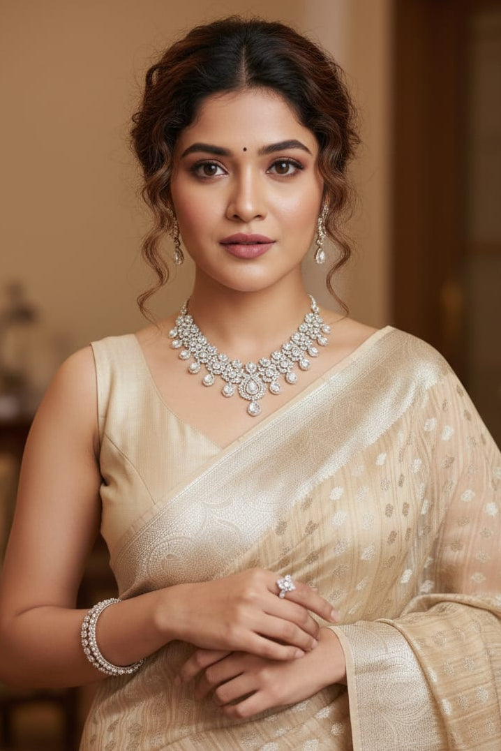 Woman in a beige saree with jewelry indoors