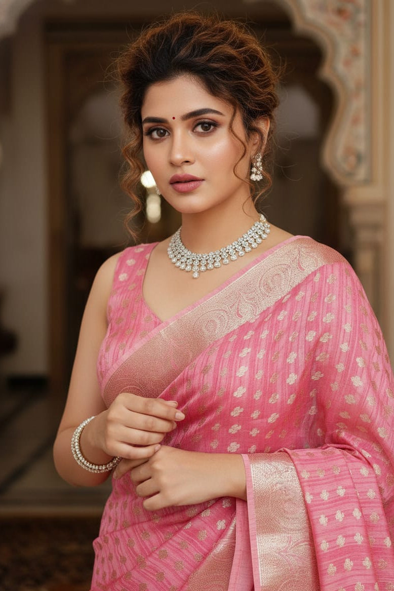 Woman in a pink saree with jewelry in an indoor setting
