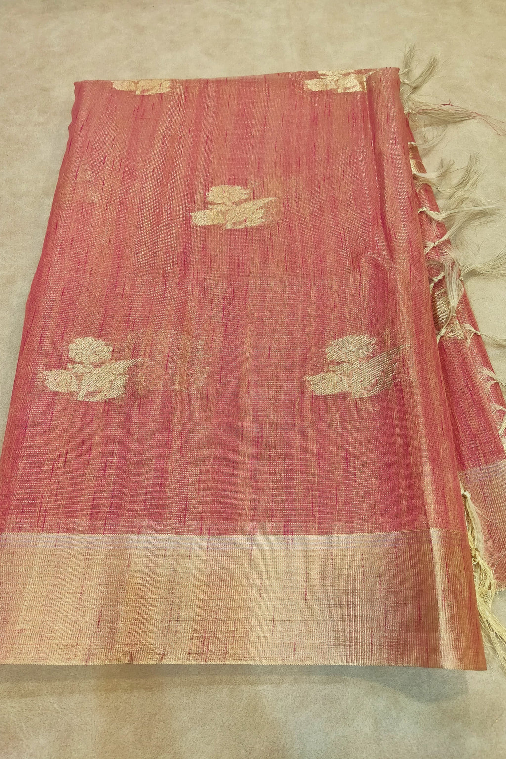 Red fabric with gold patterns on a beige background