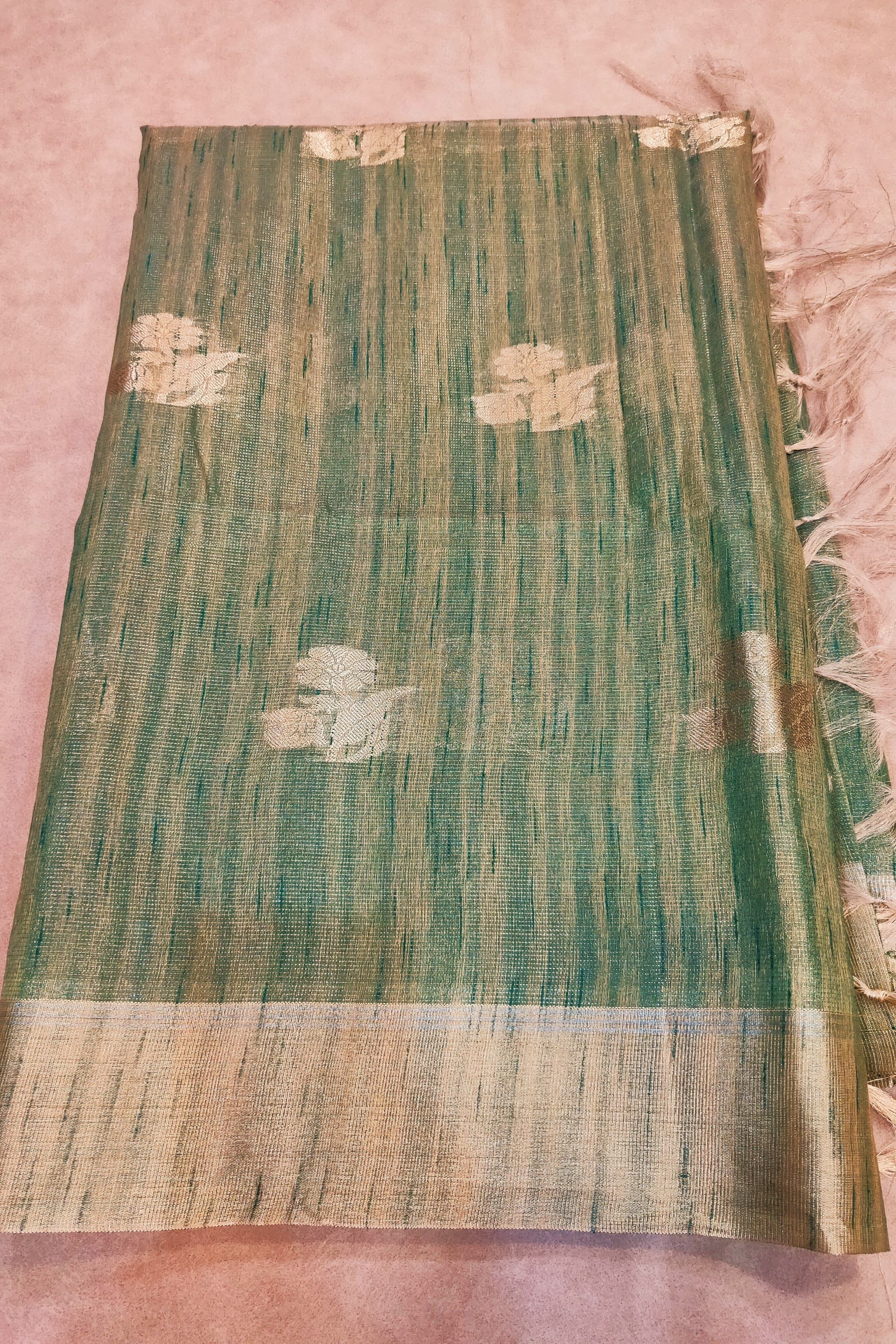 Green and beige patterned fabric on a pink background