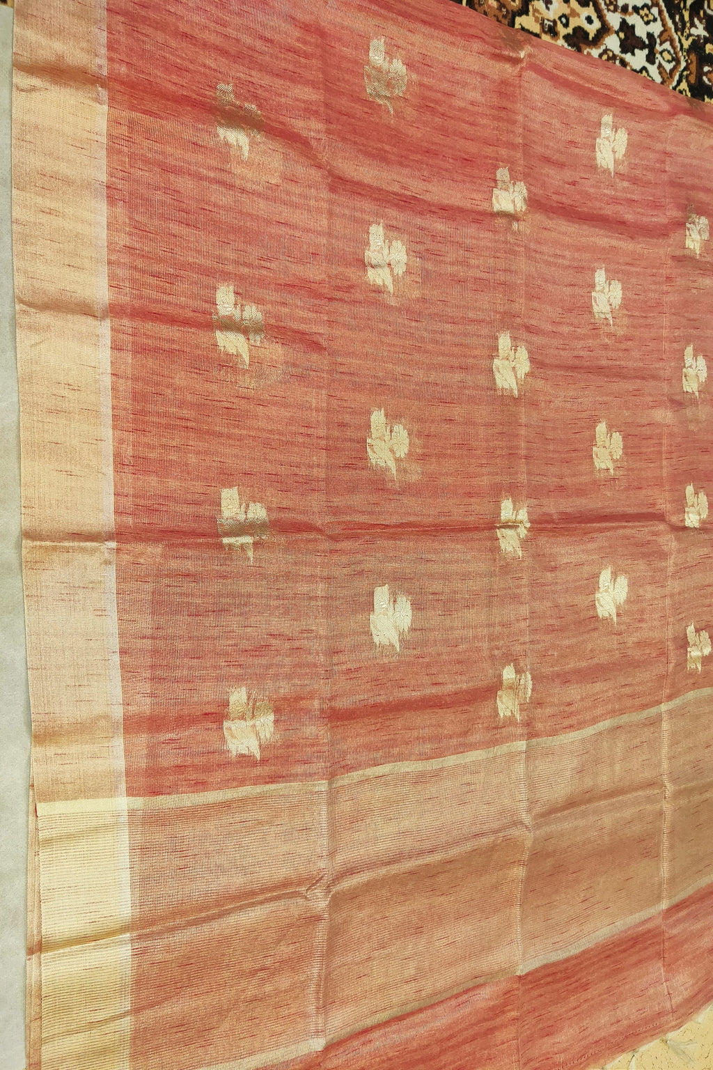 Red fabric with gold patterns on a wooden surface