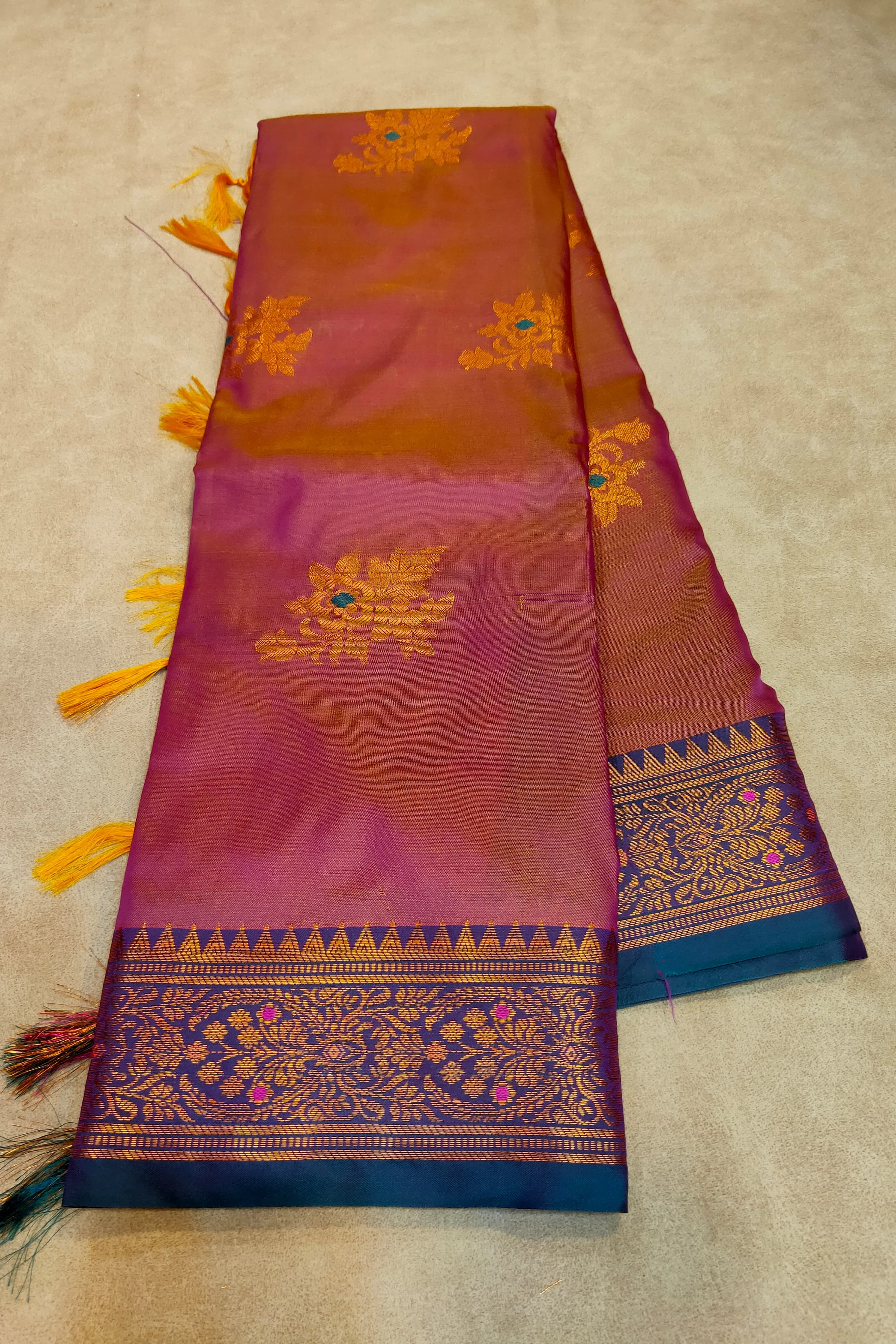 Decorative scarf with intricate patterns and tassels on a beige background